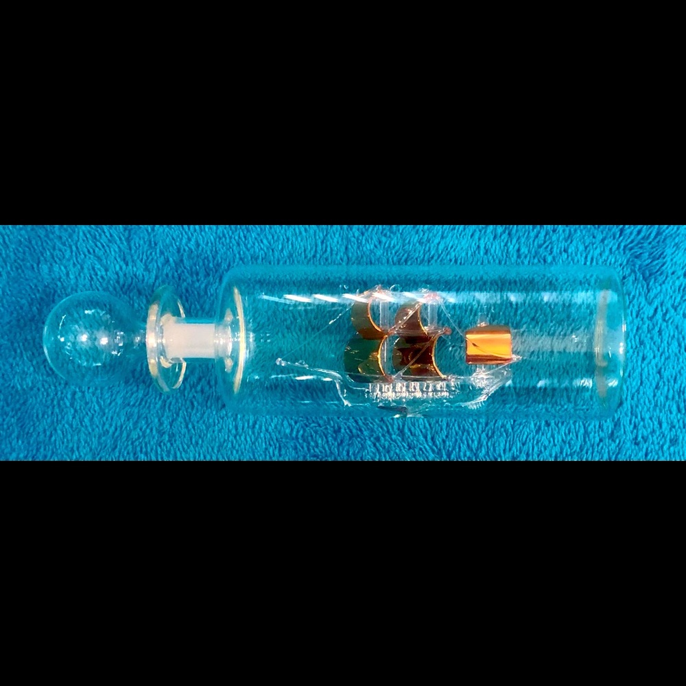Vintage Hand Blown Crystal Ship with Gold Colored Sails in a Clear Glass Bottle.